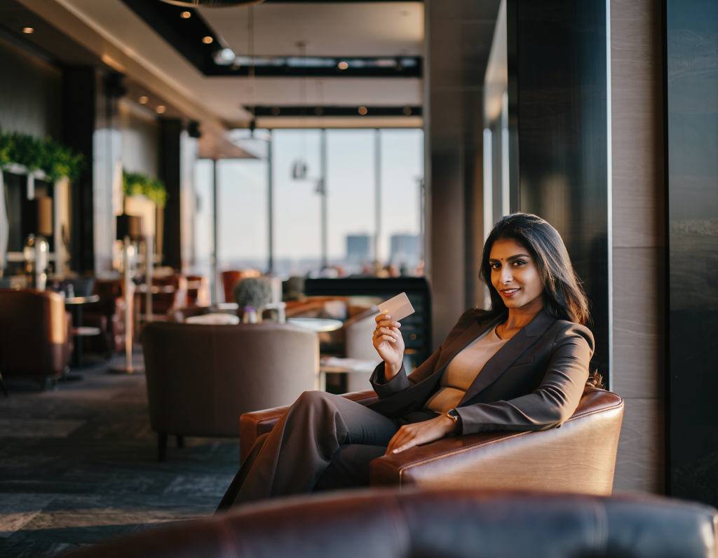 Business traveller relaxing in a modern airport lounge before flight, representing premium credit card lounge access benefits..