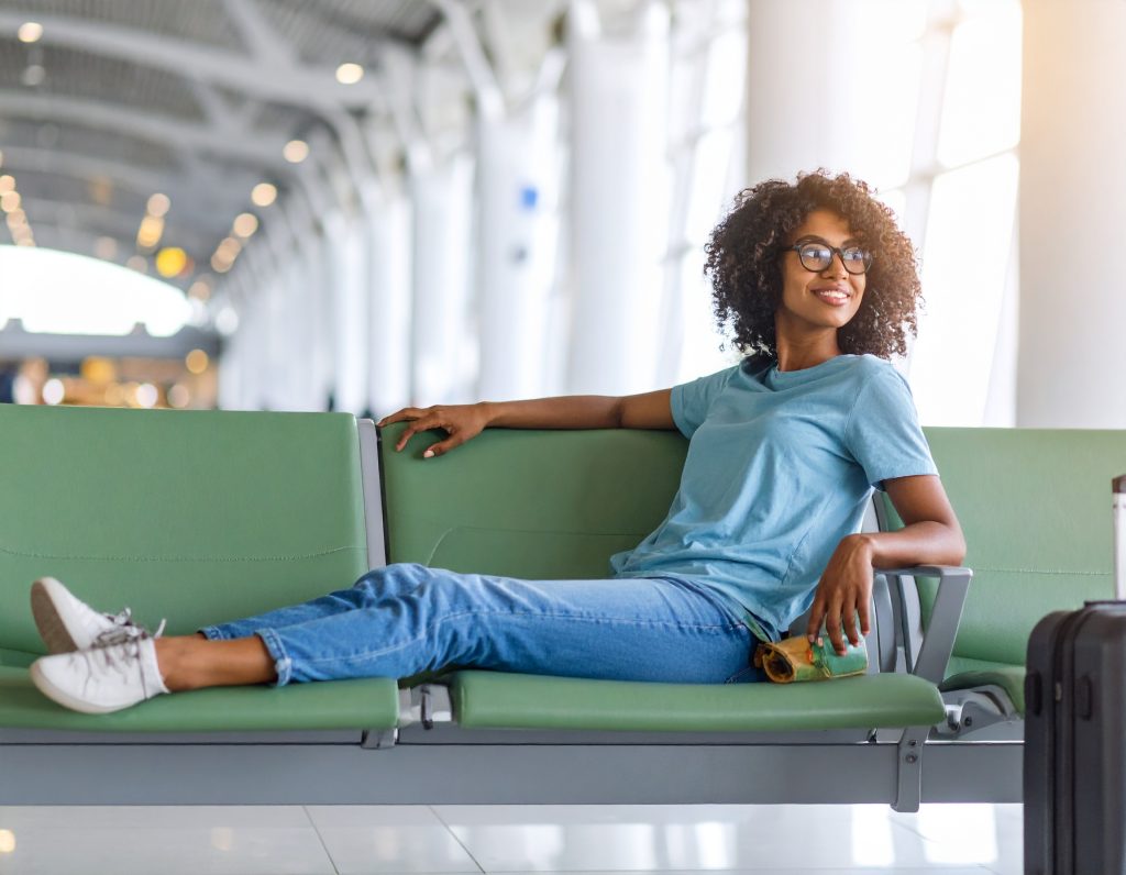 Traveler relaxing in a premium lounge at Dubai International Airport with calm lighting and modern interiors.
