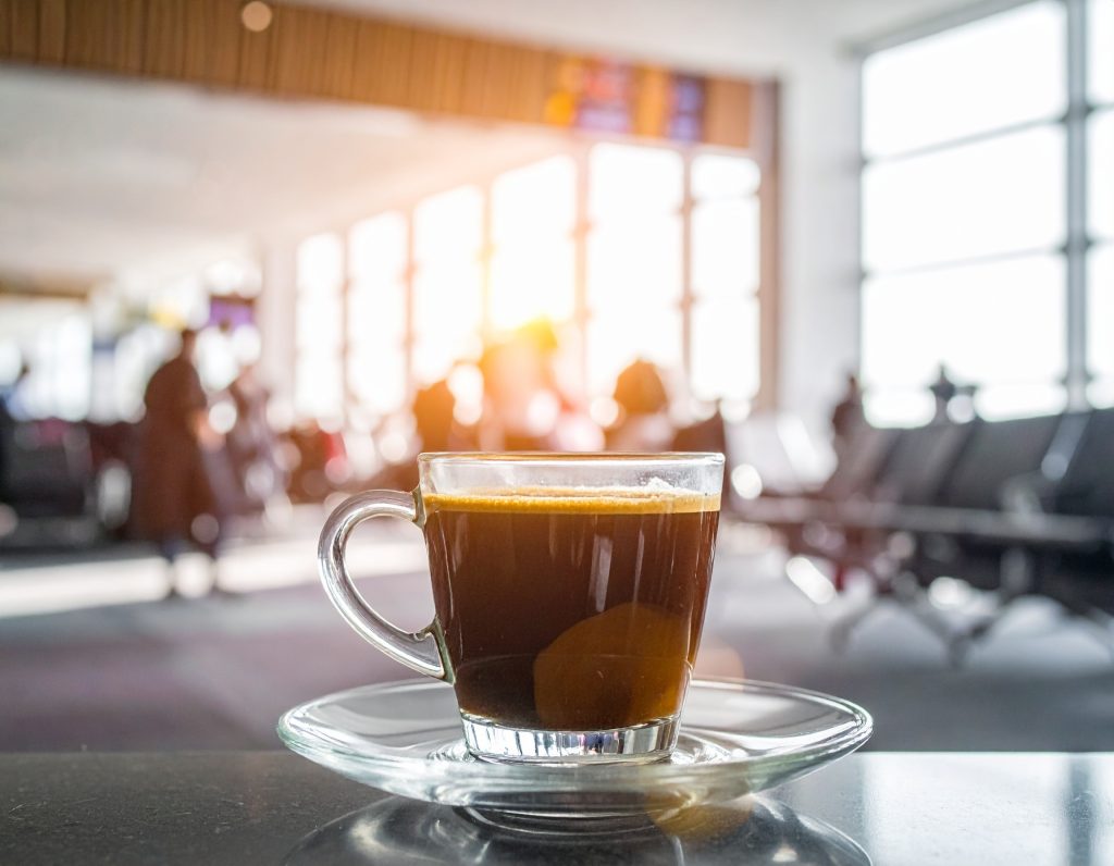 Barista preparing coffee at Costa Coffee inside airport.