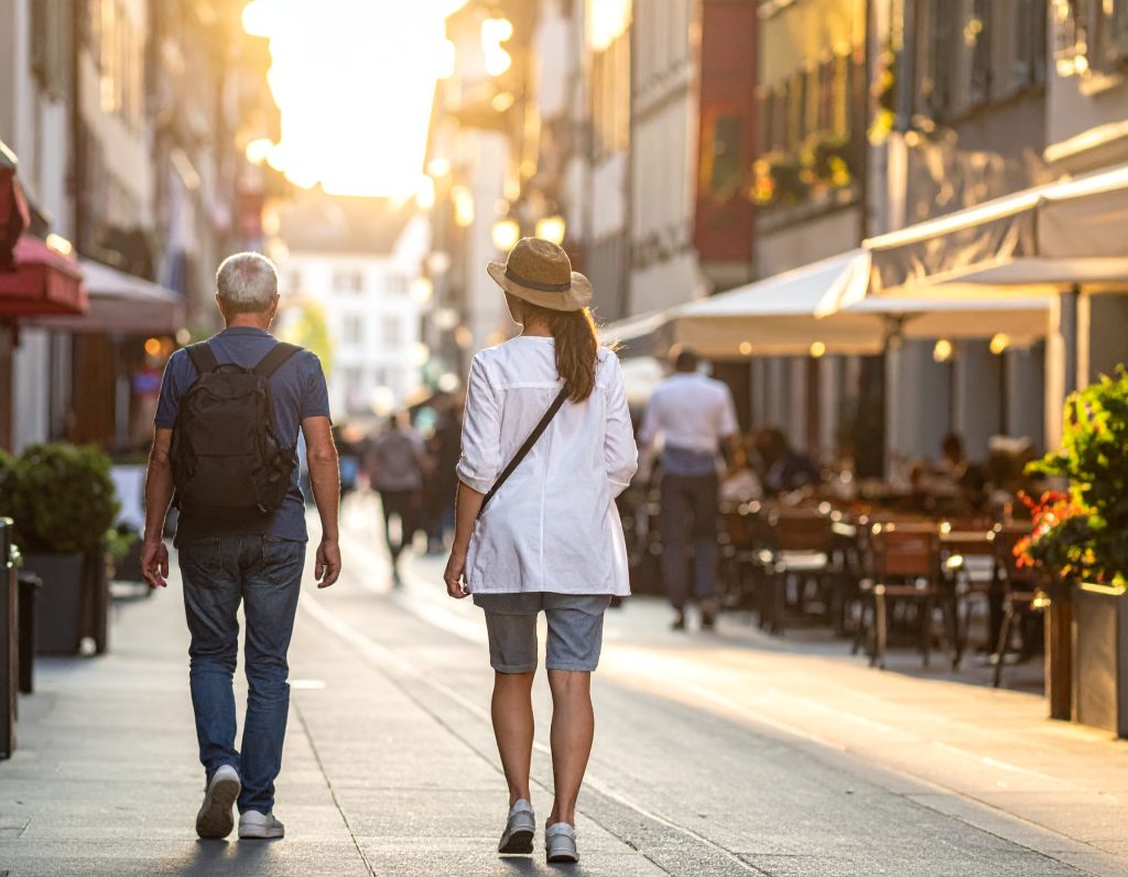 Travelers strolling past cafes in Zurich Altstadt.