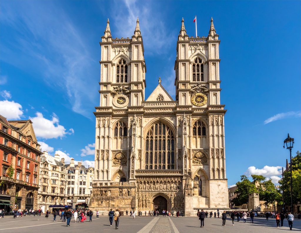 Front view of Westminster Abbey with Parliament in background.
