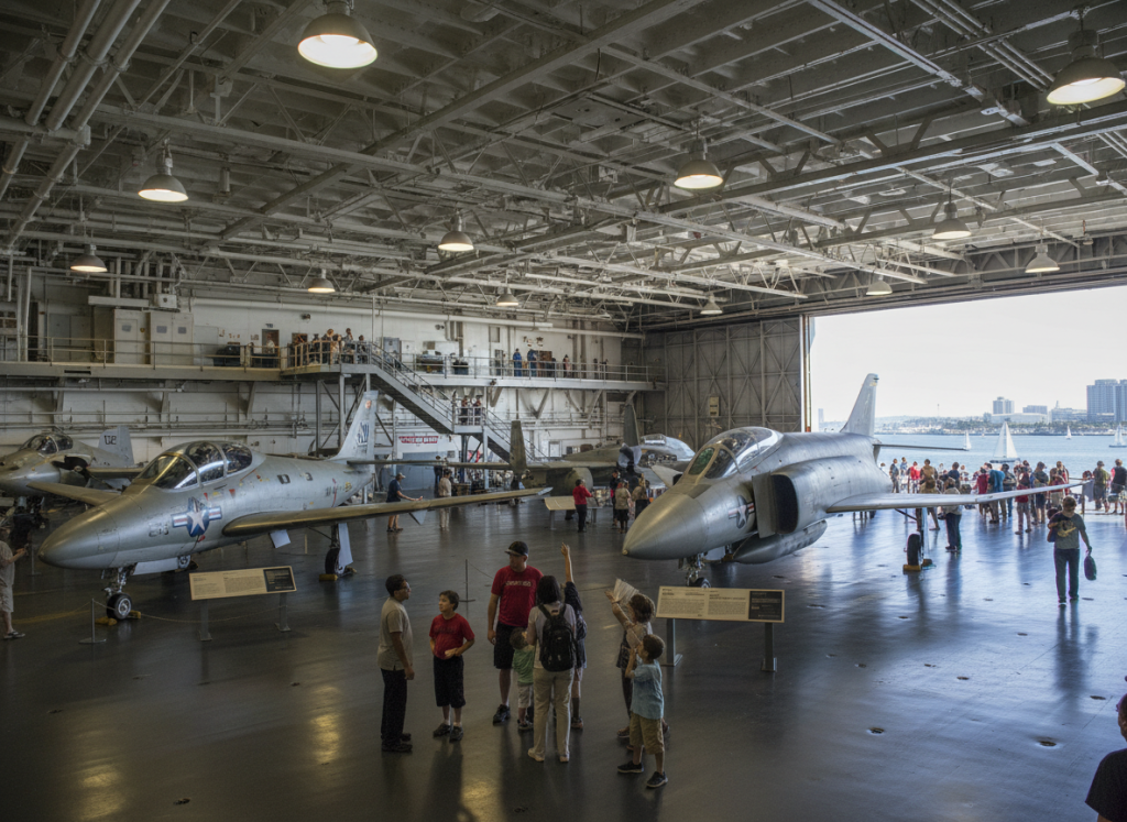 Visitors exploring aircraft hangar inside USS Midway Museum.